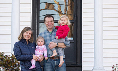 The Woodcock family stands outside their 101-year-old home in Maine.