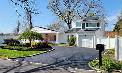 Front view of a home with solar panels on the roof.
